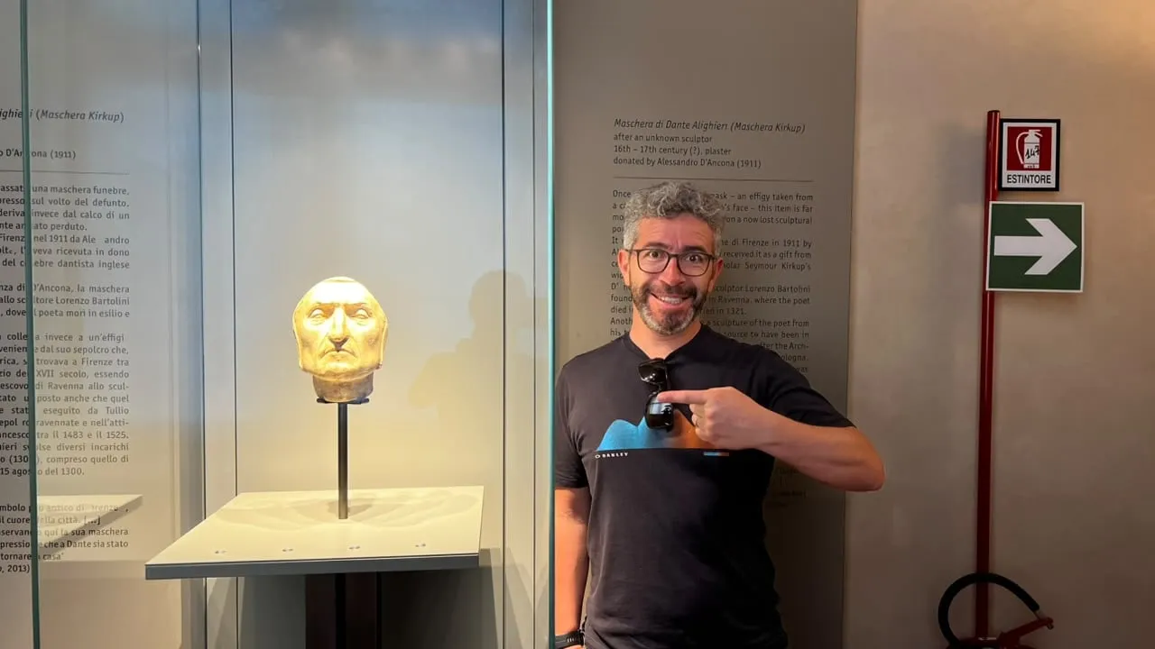 Jorge sonríe y apunta hacia la vitrina con la máscara atribuida a Dante, en un museo de Florencia